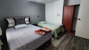 a room with two beds and a door to a bedroom at Departamento amplio y bonito en Arequipa 1er Piso in Arequipa