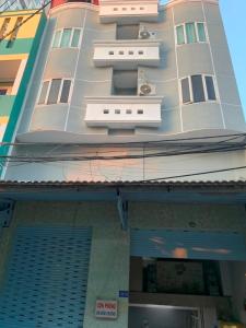 een hoog wit gebouw met twee ramen erop bij Trung Bảo Hotel in Ho Chi Minh-stad