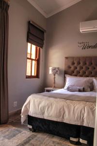 a bedroom with a large bed and a window at C-Vu-Cottage cosy and warm private apartment in Mossel Bay