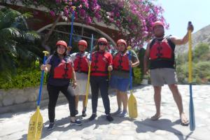 a group of people wearing life jackets and holding paddles at Hostal Aventura Total Perú_lunahuana in Lunahuaná