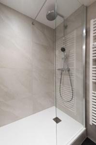 une douche avec une porte vitrée dans une salle de bain dans l'établissement Le Cachat - hyper centre - wifi gratuit, à Évian-les-Bains 23 autres photos