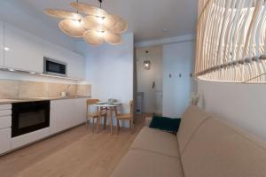 un salon avec un canapé et une cuisine avec une table dans l'établissement Le Cachat - hyper centre - wifi gratuit, à Évian-les-Bains