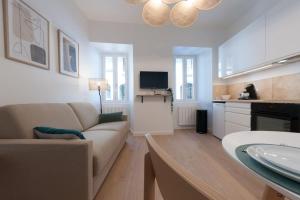 un salon avec un canapé et une télévision dans l'établissement Le Cachat - hyper centre - wifi gratuit, à Évian-les-Bains