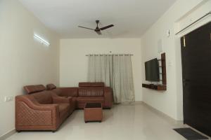 un soggiorno con divano marrone e TV di Mee Homes - Madhapur Fully Furnished 2 BHK Flats a Hyderabad