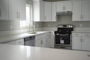 a white kitchen with white cabinets and a sink at Just Built! Brand New! Insta-Worth Private! Luxurious Home! in San Bernardino