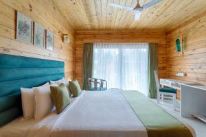 a bedroom with a large bed in a wooden room at Aralea Beach Resort By Stone Wood Premier in Morjim +35 photos