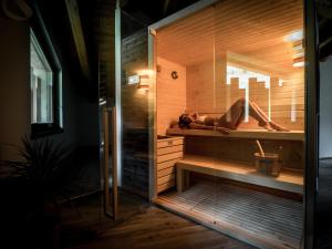 une femme qui se couche dans un sauna dans une pièce dans l'établissement Agriturismo Piane, à Ono Degno