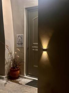 a light next to a door with a plant next to it at Aura House in Koutsopódhion