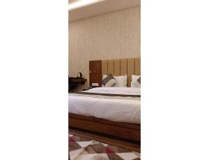 een slaapkamer met een bed met witte lakens en kussens bij HOTEL P & S VINDHYA, Dehri in Sidhauli