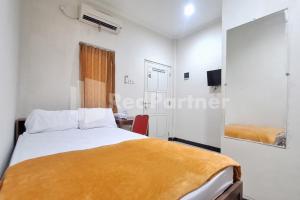 a small bedroom with a bed and a desk at De Peppzzz near UGM Yogyakarta RedPartner in Kejayan