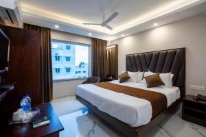 Un dormitorio con una cama grande y una ventana en PARKKAVAN TOWERS en Tiruchchirāppalli