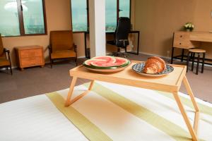 een tafel met een fruitschaal en een bord brood bij Appartement T2 avec ascenseur privé in Antananarivo