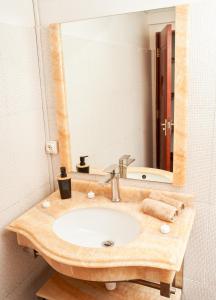 een badkamer met een wastafel en een spiegel bij Appartement T2 avec ascenseur privé in Antananarivo