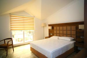 um quarto com uma cama grande e uma janela em Oludeniz Turquoise Hotel - All Inclusive em Oludeniz