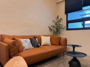 台東市的住宿－tt-house台東包棟民宿，客厅配有带枕头的棕色沙发