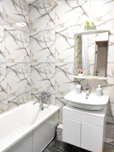 y baño con lavabo blanco y espejo. en Аккуратная 1-комнатная квартира в ЖК Nomad, en Almaty