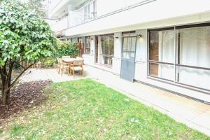 a patio with a table and a tree at Appart with Garden - 15 min from Eiffel Tower in Boulogne-Billancourt