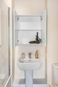 a white bathroom with a sink and a shower at Luxury balcony in Colindale in Hendon