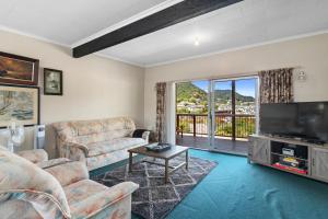 un soggiorno con divani e TV a schermo piatto di Coastal Charm - Picton Holiday Home a Picton