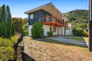 una casa con balcone sul lato di Coastal Charm - Picton Holiday Home a Picton