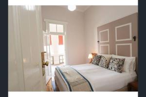 a bedroom with a bed with pillows and a window at The Bank Main Street Apartment in West Wyalong