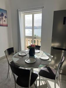 a table and chairs with a table and a window at Luxurious Beach Apartment in Birżebbuġa