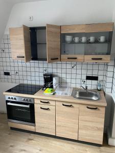 a kitchen with a sink and a stove at Monteurwohnung Haus Elbert Hagen 2 in Hagen