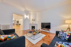 un soggiorno con 2 divani e un camino di Magnifique Appartement de luxe & familial avec Parking - Paris 16 a Parigi