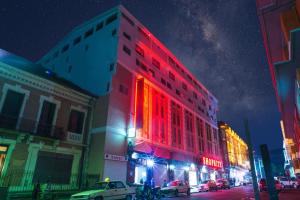 een gebouw met rode lichten in een stadsstraat 's nachts bij Appartement T2 avec ascenseur privé in Antananarivo