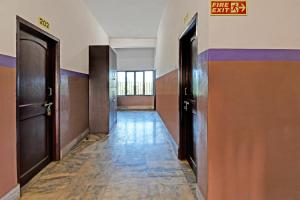 an empty hallway with two doors and a sign on the wall at Chilika Residency in Bhubaneshwar