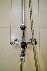 a shower head with a hose in a bathroom at Hil Venture in Arusha