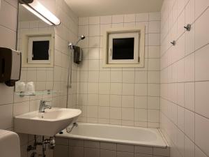 y baño con lavamanos, bañera y lavamanos. en Notodden Hotel, en Notodden