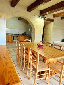 un tavolo e sedie in legno in cucina di Ortensia a Taʼ Bullara