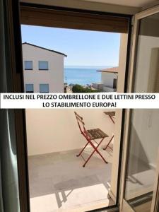 balcón con vistas a una ventana con una silla en RS304 - Marcelli, nuovo bilo fronte mare con spiaggia inclusa, en Marcelli