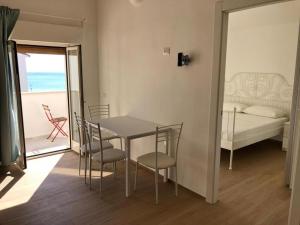 comedor con mesa, sillas y cama en RS304 - Marcelli, nuovo bilo fronte mare con spiaggia inclusa, en Marcelli
