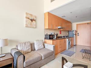 a living room with a couch and a kitchen at Studio Unit In Lincoln Park B In Arjan in Dubai