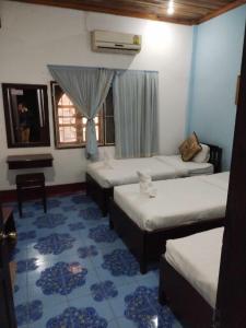 Zimmer mit 3 Betten und einem Fenster in der Unterkunft Phanh Tha Sone House in Luang Prabang