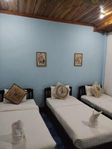 2 Betten in einem Zimmer mit blauer Wand in der Unterkunft Phanh Tha Sone House in Luang Prabang