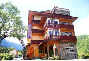 a wooden building with a balcony on top of it at Kingtaiwan Hotel in Lugu Lake