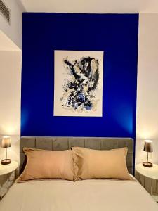 a blue wall above a bed in a bedroom at Vanilla latte 1bedroom Apt @the Greens in Dubai