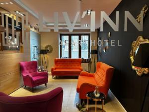 una sala de espera con sillas de color naranja y rosa en Liv'Inn Aparthotel, en Cracovia