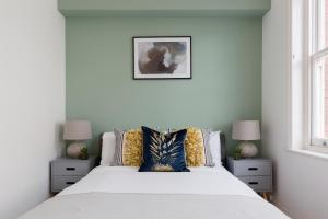 a bedroom with a white bed with two night stands at The Aldgate Flat in London