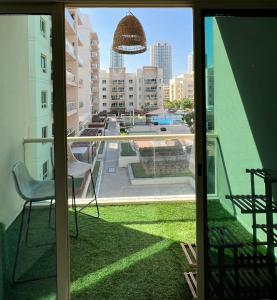 balcón con silla y vistas a la ciudad en Vanilla latte 1bedroom Apt @the Greens, en Dubái