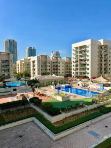 a swimming pool in a city with tall buildings at Vanilla latte 1bedroom Apt @the Greens in Dubai
