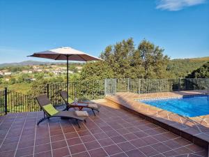 a patio with two chairs and an umbrella next to a pool at Casa Del Ingles - Luxury Private Villa & Pool in Rural Valley in Pontevedra