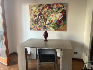 a table with a vase on top of it with a painting at Oasi di serenità in Fregene