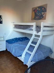 a white bunk bed with a ladder next to a bed at Oasi di serenità in Fregene