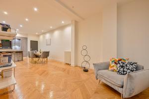 uma sala de estar com um sofá e uma mesa em Magnifique Appartement de luxe & familial avec Parking - Paris 16 em Paris
