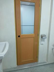 a wooden door in a bathroom with a sink at Dilani Adamspeak RiverStay in Adams Peak