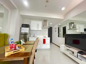 a kitchen with a dining table and a television at Sakura apartment in Manila